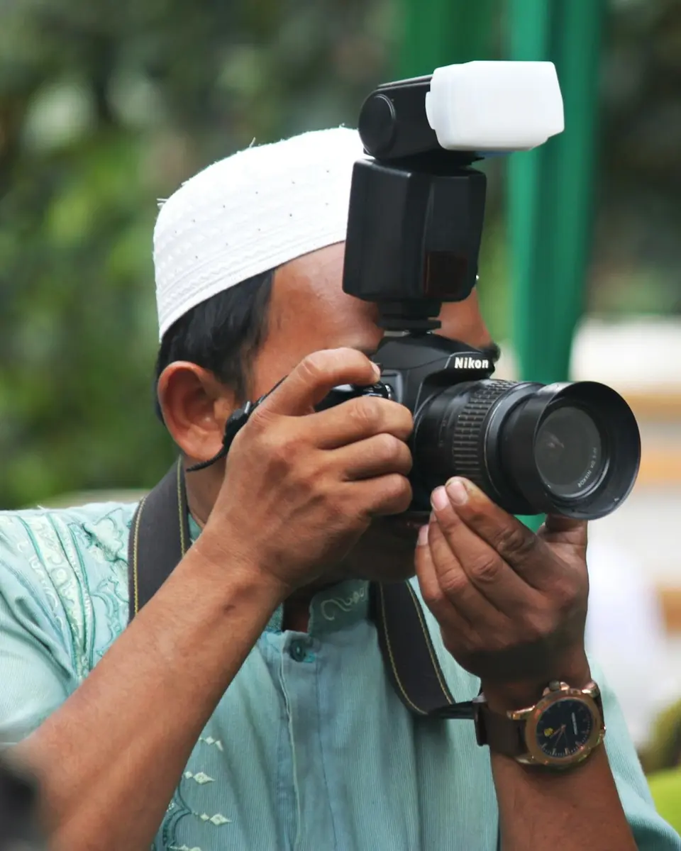 Fotografer memotret acara dengan kamera dan lampu kilat