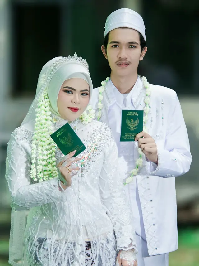 Pasangan pengantin memegang buku nikah