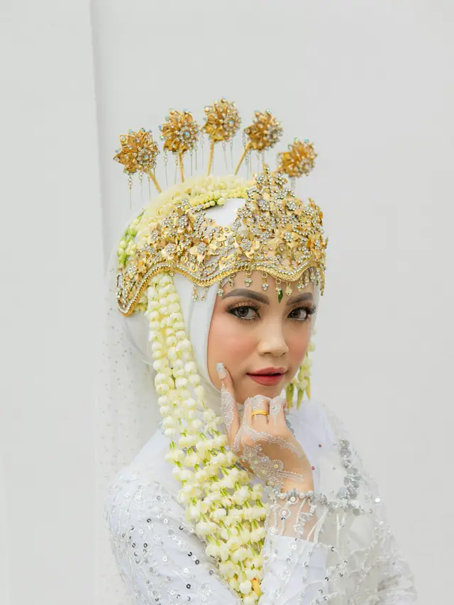 Pengantin dengan siger emas dan kerudung putih