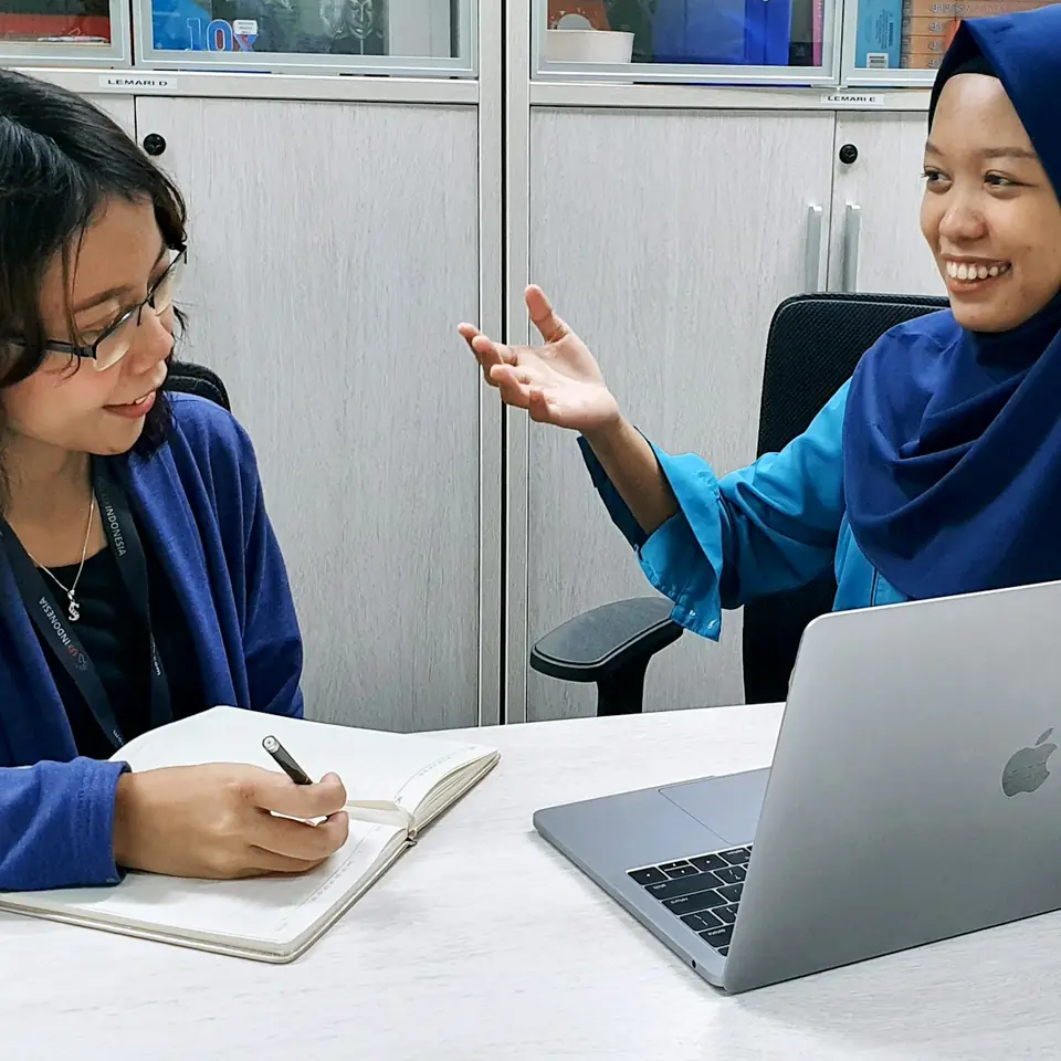 Konsultan mencatat kebutuhan kliennya dalam sesi konsultasi