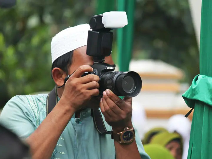 Fotografer memotret acara dengan lampu kilat
