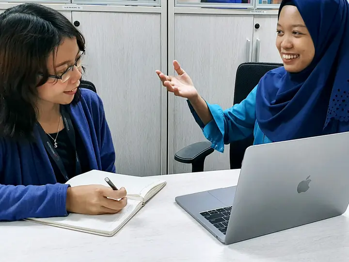 Konsultan mencatat kebutuhan kliennya dalam sesi konsultasi